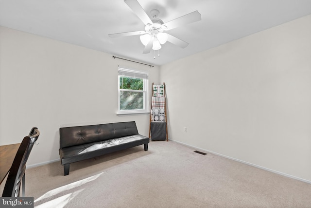 living area featuring ceiling fan and light colored carpet