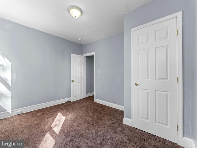 unfurnished bedroom featuring dark colored carpet