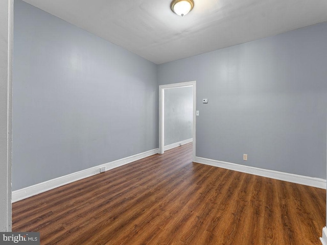 spare room with dark hardwood / wood-style flooring