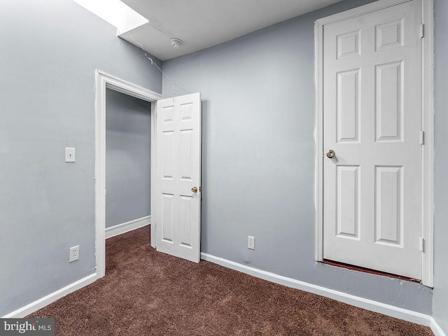 unfurnished bedroom with dark carpet