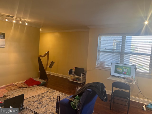 bedroom featuring ornamental molding, baseboards, track lighting, and wood finished floors