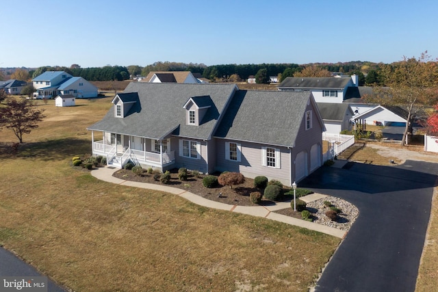 view of front of home featuring a front yard, a garage, and covered porch