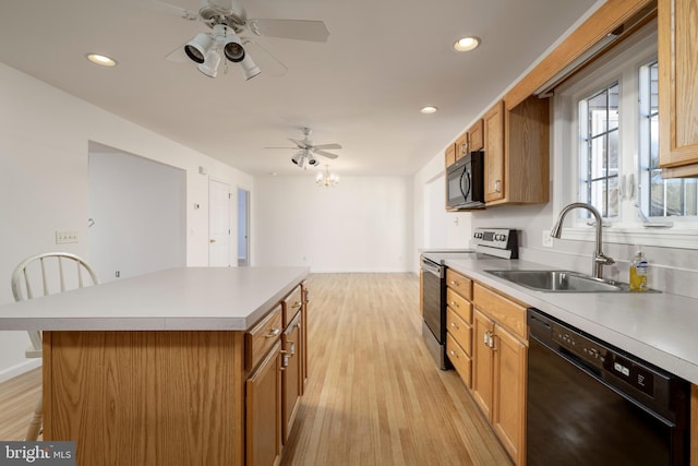 kitchen featuring black appliances, sink, light hardwood / wood-style floors, ceiling fan, and a center island