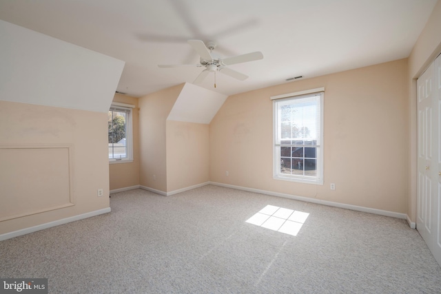 bonus room featuring lofted ceiling, light carpet, ceiling fan, and plenty of natural light