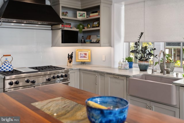 155 E Oakland Ave, Doylestown, PA 18901 - kitchen with wall chimney exhaust hood, high end stainless steel range oven, a sink, light stone counters, and white cabinets