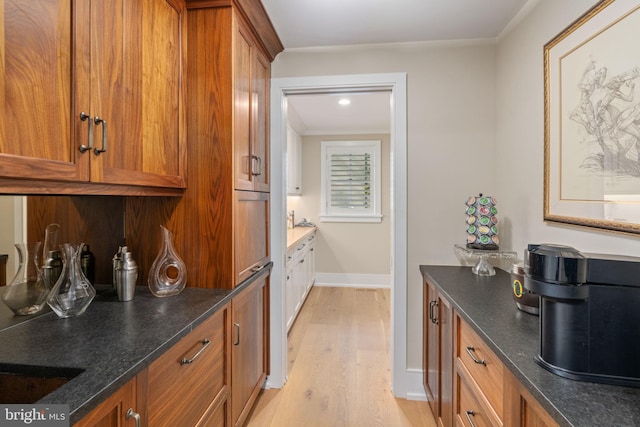 155 E Oakland Ave, Doylestown, PA 18901 - kitchen featuring brown cabinetry, light wood finished floors, dark stone countertops, and baseboards