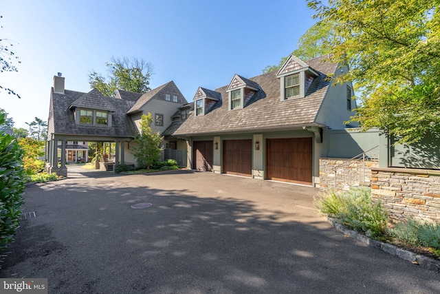 155 E Oakland Ave, Doylestown, PA 18901 - view of front of property featuring asphalt driveway, a chimney, an attached garage, and stone siding