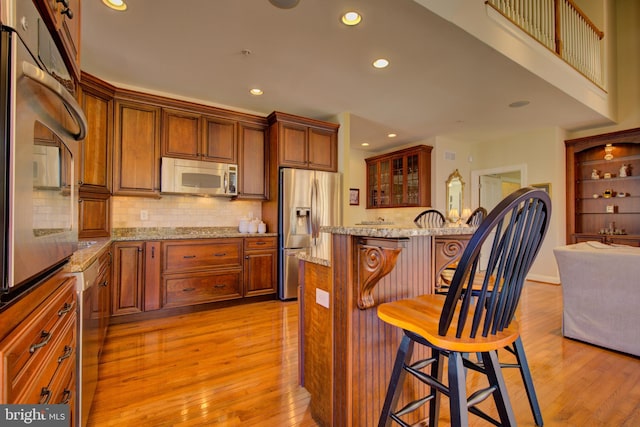 kitchen featuring light hardwood / wood-style floors, stainless steel appliances, and a breakfast bar area