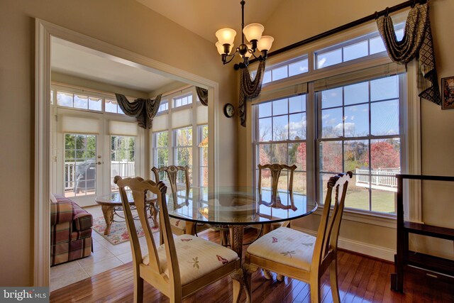 dining area with wood-type flooring and a chandelier