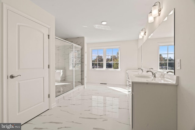 bathroom with a marble finish shower, marble finish floor, a healthy amount of sunlight, and a sink