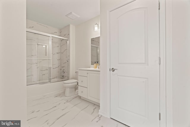 bathroom with vanity, toilet, marble finish floor, and enclosed tub / shower combo