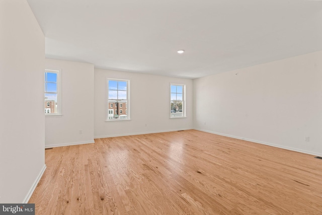 unfurnished room featuring baseboards and light wood-style floors