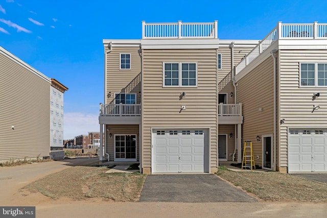 view of front of home featuring a balcony, driveway, and an attached garage
