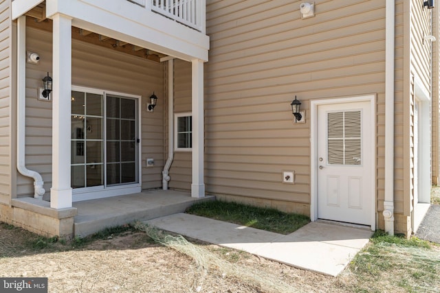 view of exterior entry with a balcony