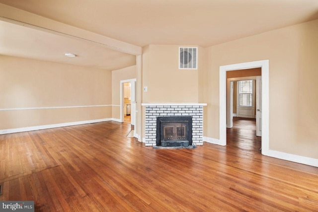 205 Walnut St, Pocomoke City, MD 21851 - unfurnished living room with wood finished floors, a brick fireplace, and baseboards