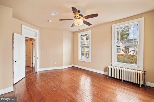 205 Walnut St, Pocomoke City, MD 21851 - spare room featuring radiator, hardwood / wood-style flooring, ceiling fan, and baseboards
