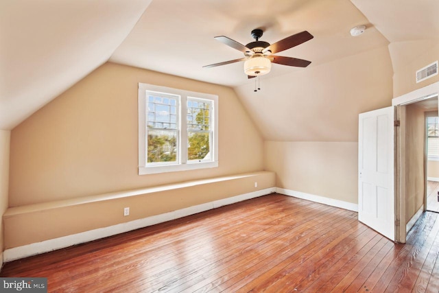 bonus room with hardwood / wood-style floors, a healthy amount of sunlight, ceiling fan, and vaulted ceiling with skylight