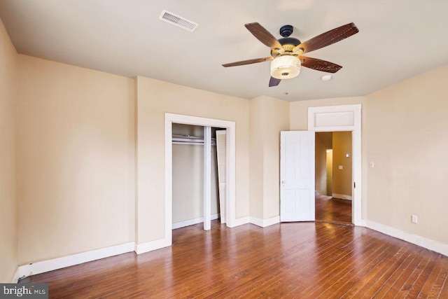 unfurnished bedroom featuring ceiling fan, dark hardwood / wood-style floors, and a closet