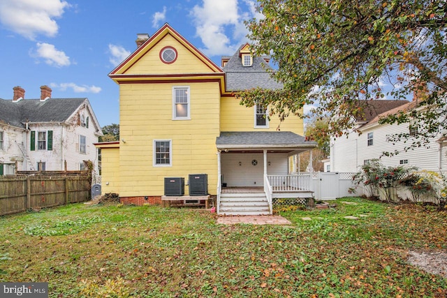 rear view of house with central air condition unit, a yard, and a deck