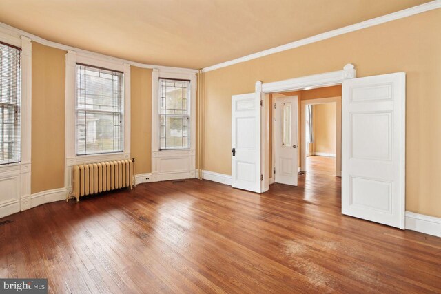 205 Walnut St, Pocomoke City, MD 21851 - unfurnished room featuring radiator, wood finished floors, crown molding, and baseboards