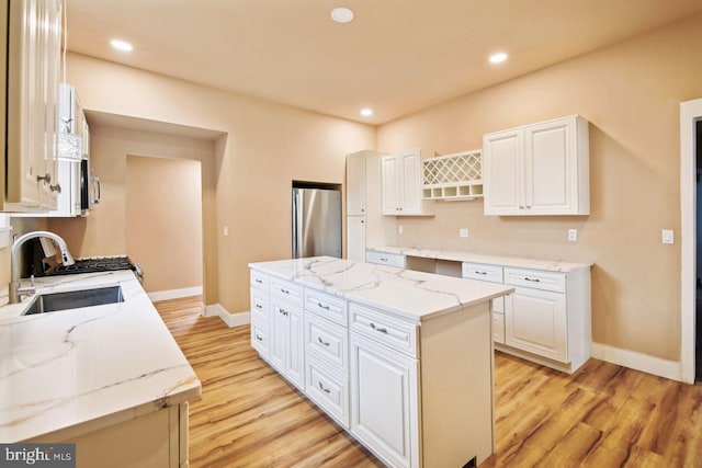 205 Walnut St, Pocomoke City, MD 21851 - kitchen featuring freestanding refrigerator, a sink, light wood-type flooring, a kitchen island, and recessed lighting
