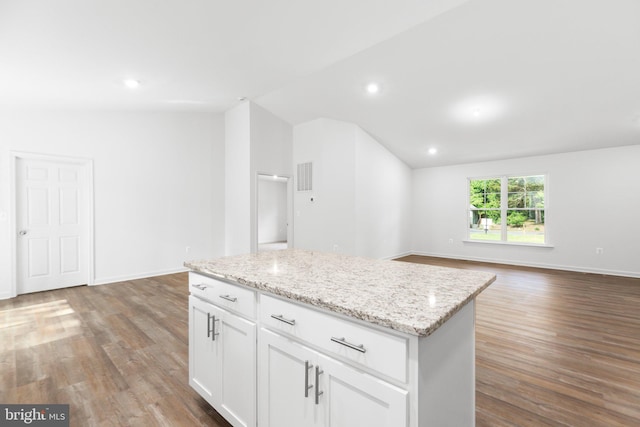 kitchen with light wood-type flooring, a center island, lofted ceiling, white cabinets, and light stone counters