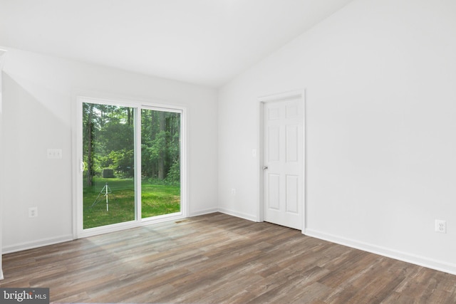 empty room with hardwood / wood-style flooring and lofted ceiling