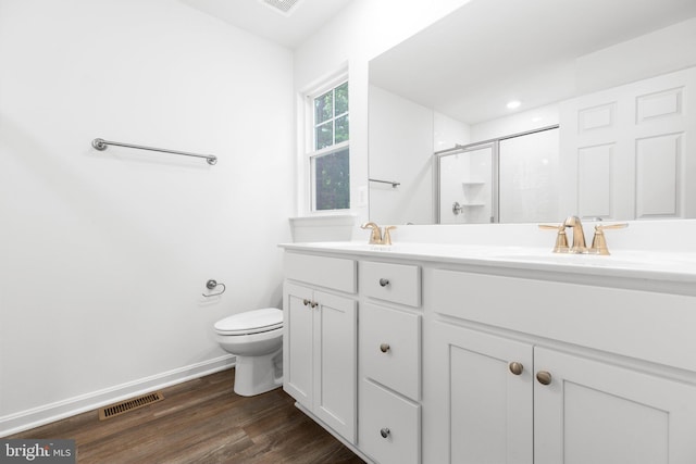 bathroom with vanity, toilet, a shower with door, and hardwood / wood-style floors