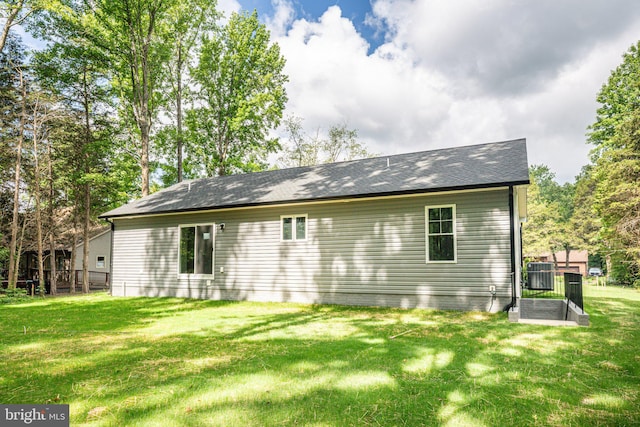 back of house featuring central AC and a lawn