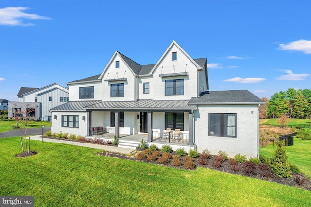 9142 Belvedere Branch Dr, Great Falls, VA 22066 - modern farmhouse with covered porch, a front lawn, a standing seam roof, brick siding, and roof with shingles
