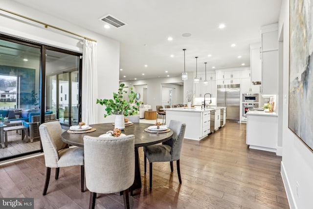 dining space with hardwood / wood-style floors and sink