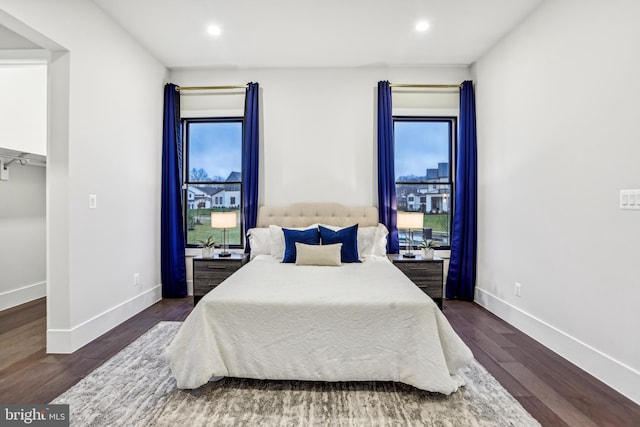 bedroom featuring multiple windows and dark hardwood / wood-style floors