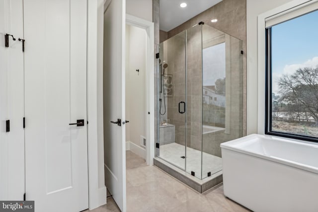 bathroom featuring tile patterned floors, plenty of natural light, and plus walk in shower