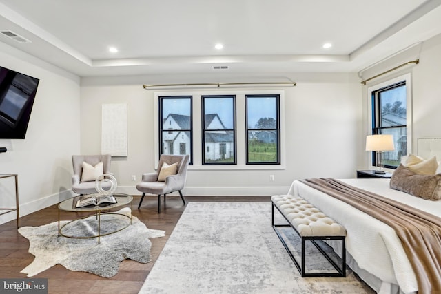 bedroom featuring hardwood / wood-style floors and a raised ceiling