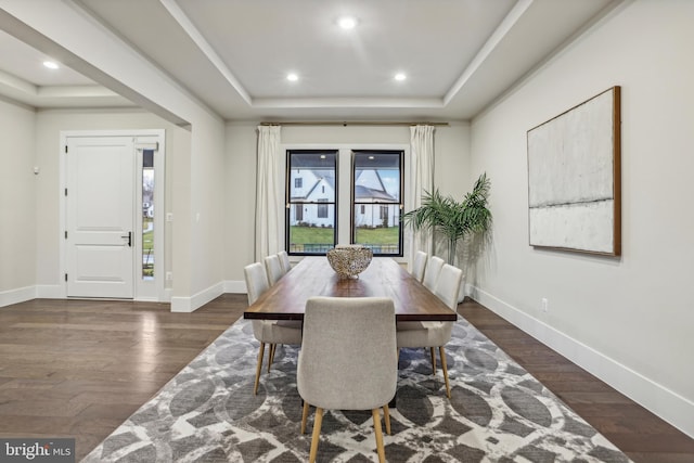 dining room featuring dark hardwood / wood-style floors and a tray ceiling