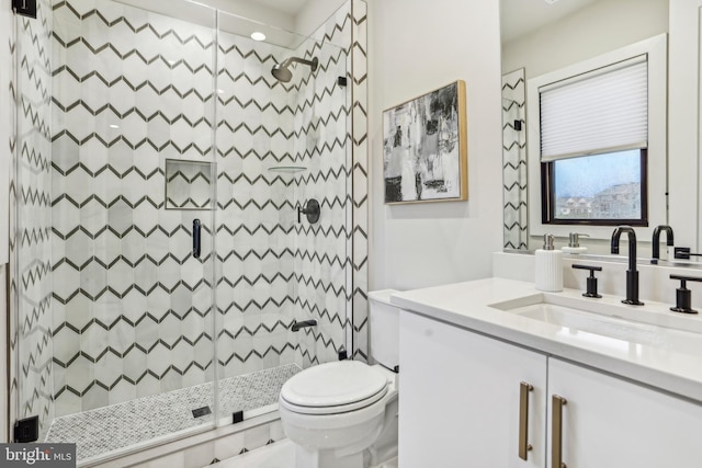 bathroom featuring a shower, vanity, and toilet