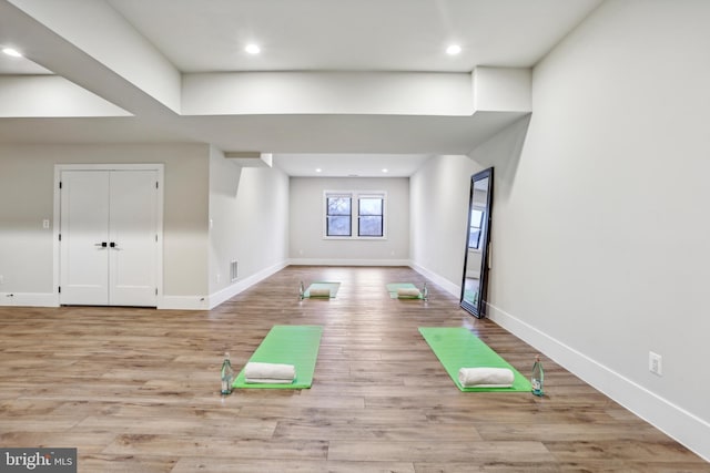 exercise room featuring light wood-type flooring