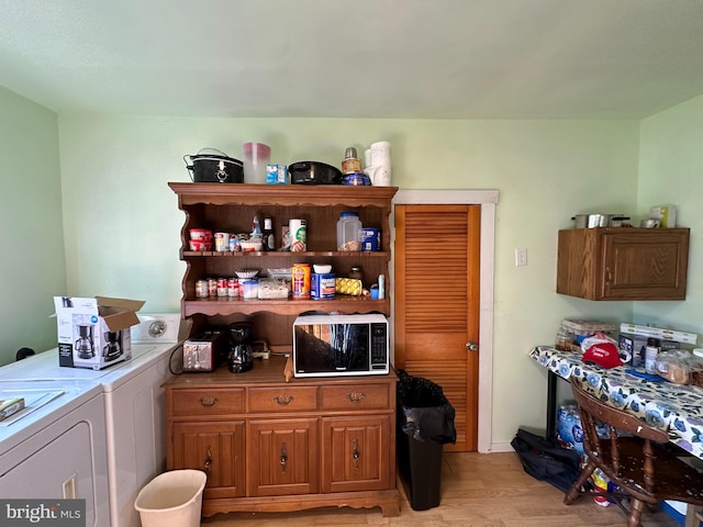 interior space featuring light wood-type flooring, cabinets, and washing machine and dryer