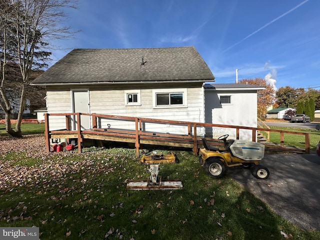 rear view of property with a wooden deck and a yard