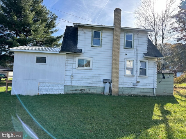 rear view of house featuring a yard