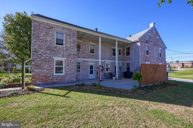 back of house with a yard and a patio