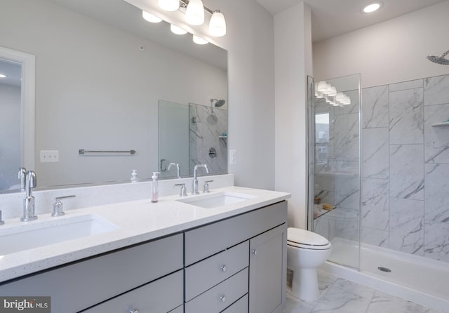 bathroom with toilet, vanity, and tiled shower