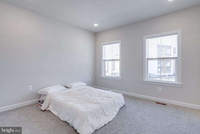 bedroom featuring carpet flooring and multiple windows