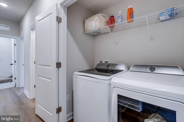 laundry area featuring light hardwood / wood-style floors and independent washer and dryer