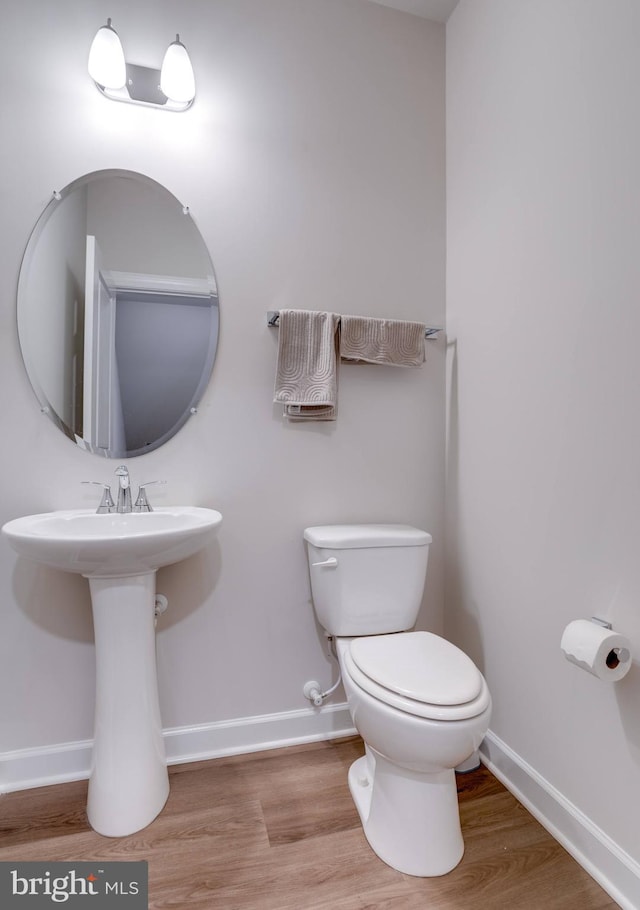 bathroom featuring hardwood / wood-style flooring, toilet, and sink