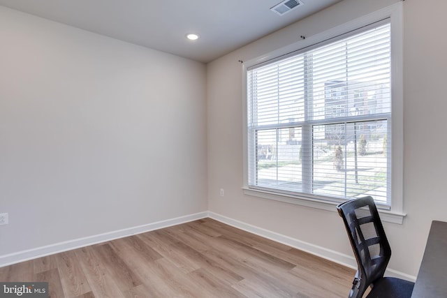 unfurnished office featuring light wood-type flooring and plenty of natural light