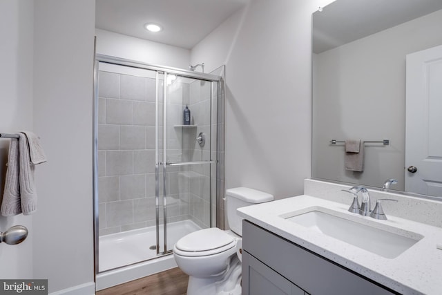 bathroom featuring hardwood / wood-style floors, vanity, toilet, and an enclosed shower