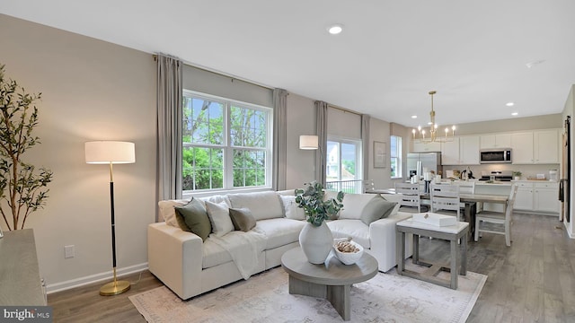 living room with light hardwood / wood-style floors and a chandelier