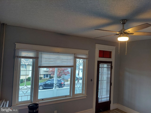 entryway featuring a textured ceiling, wood-type flooring, and ceiling fan