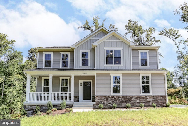 craftsman-style home featuring covered porch, stone siding, and board and batten siding